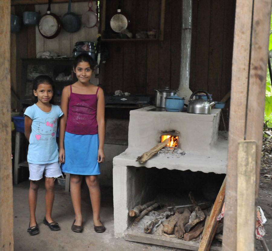Girls next to lit cookstove